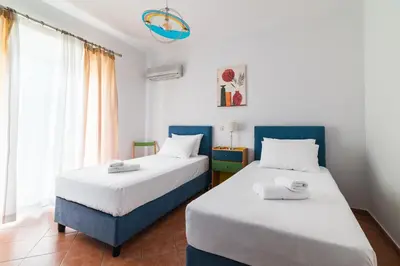 two beds in a room with white and blue at Villa Del Mar in Ialyssos