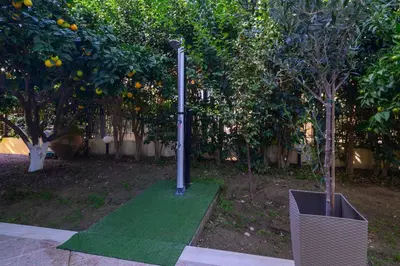 a garden with two orange trees and a green lawn at Villa Del Mar in Ialyssos