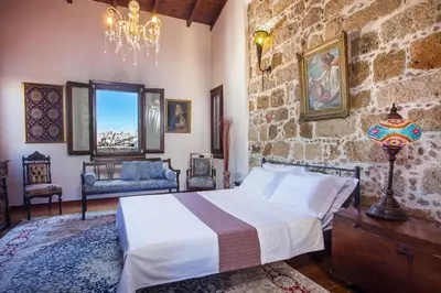 a bedroom with a bed and a stone wall at CASA DI ALEJANDRO in Rhodes Town