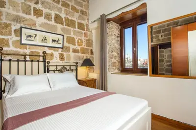 a bedroom with a bed and a stone wall at CASA DI ALEJANDRO in Rhodes Town
