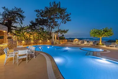 a swimming pool with tables and chairs around it at Aegean View Estates in Faliraki