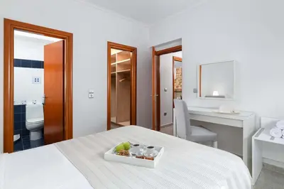 a bedroom with a bed with a tray of fruit on it at Aegean View Estates in Faliraki