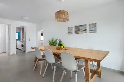 a dining room with a wooden table and white chairs at Aegean View Estates in Faliraki