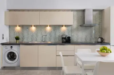 a kitchen with a washing machine and a table with chairs at Aegean View Estates in Faliraki