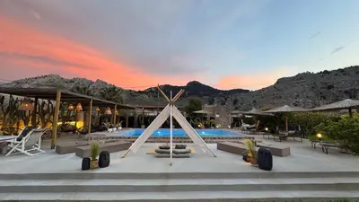 a resort with a swimming pool with mountains in the background at LA Casa Di Lusso N7 -Adults Only in Kolimbia