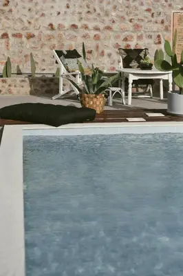 a swimming pool in front of a brick wall at LA Casa Di Lusso N7 -Adults Only in Kolimbia