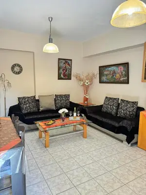 a living room with black couches and a table at George's & Amalia's appartments 2 in Afantou