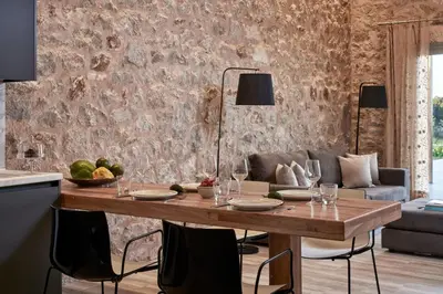 a dining room with a table and a couch at Anar Villas Rhodes in Koskinou
