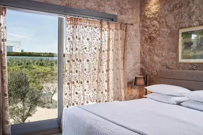 a bedroom with a bed and a large window at Anar Villas Rhodes in Koskinou