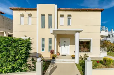 a large white house with a white door at Rose Garden House in Kremasti