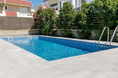 a swimming pool in front of a house at Rose Garden House in Kremasti