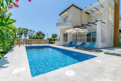 a villa with a swimming pool and a house at Rose Garden House in Kremasti