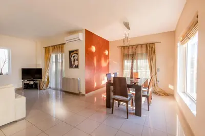 a dining room with a table and chairs at Rose Garden House in Kremasti