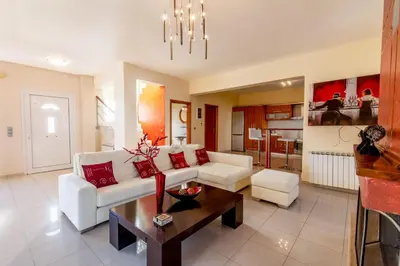 a living room with a couch and a table at Rose Garden House in Kremasti