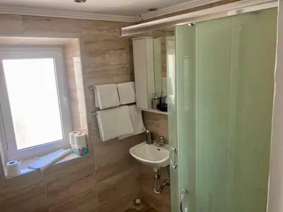 a bathroom with a glass shower and a sink at PALS Studios Lindos in Líndos