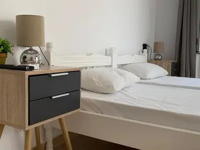 a bedroom with a white bed and a night stand at PALS Studios Lindos in Líndos