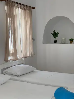 a bed in a white room with a window at PALS Studios Lindos in Líndos