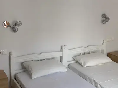 two beds in a room with white walls at PALS Studios Lindos in Líndos