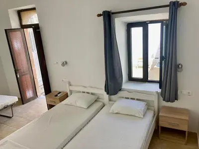 two beds in a room with a window at PALS Studios Lindos in Líndos