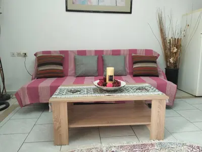 a living room with a pink couch with a table at Old House in Paradeísion