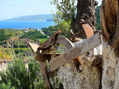 a wooden sign attached to a tree at Auberge Kalopetri in Kamiros