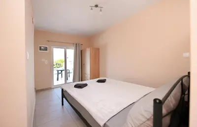 a bedroom with a bed with two black shoes on it at Happy Days Home Apartment und Studio/Penthouse in Ialyssos