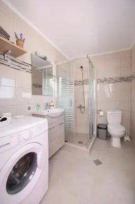a white bathroom with a washing machine in it at Happy Days Home Apartment und Studio/Penthouse in Ialyssos