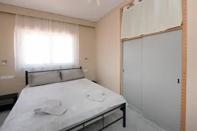 a bedroom with a bed with two towels on it at Happy Days Home Apartment und Studio/Penthouse in Ialyssos