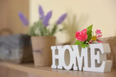 a wooden word fam sitting on a table with flowers at Happy Days Home Apartment und Studio/Penthouse in Ialyssos