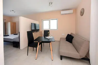 a living room with a couch and a table at Happy Days Home Apartment und Studio/Penthouse in Ialyssos