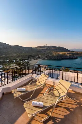 a group of chairs sitting on top of a balcony at Villa Lindos Muse in Líndos