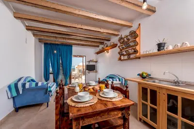 a kitchen with a wooden table with plates on it at Villa Lindos Muse in Líndos