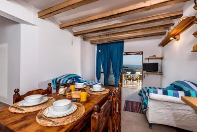 a dining room with a wooden table with food on it at Villa Lindos Muse in Líndos
