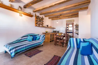 a living room with two beds and a table at Villa Lindos Muse in Líndos