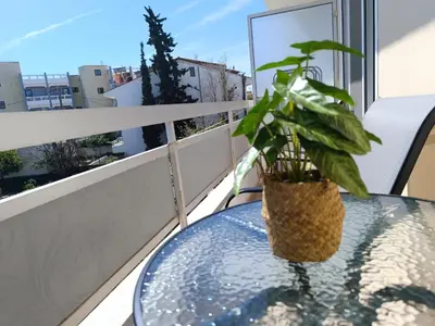 a glass table with a potted plant on a balcony at Nautilus City Studios & Apartments in Rhodes Town
