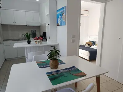 a white kitchen and living room with a table and chairs at Nautilus City Studios & Apartments in Rhodes Town