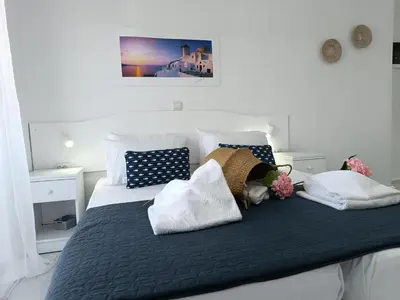 a bed with white and blue pillows on it at Nautilus City Studios & Apartments in Rhodes Town