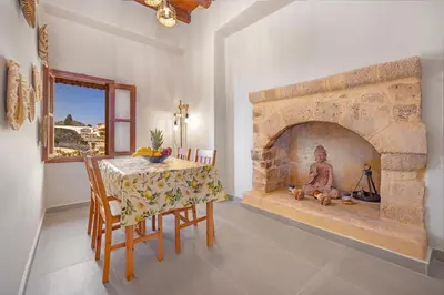 a dining room with a table and a stone fireplace at Casa Della vita Loft ,Rhodes Old town in Rhodes Town