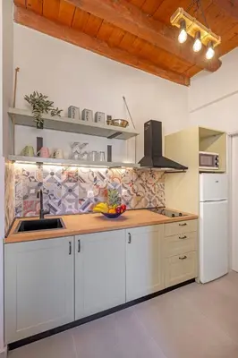 a kitchen with white cabinets and a wooden counter top at Casa Della vita Loft ,Rhodes Old town in Rhodes Town