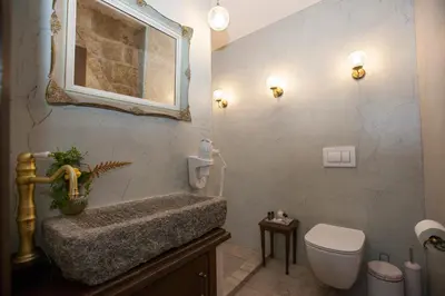 a bathroom with a sink and a toilet and a mirror at Porolithos Boutique Hotel in Rhodes Town