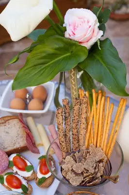 a vase with a rose and some food on a table at Porolithos Boutique Hotel in Rhodes Town
