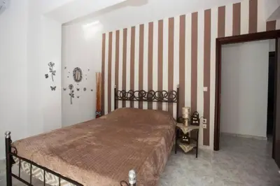 a bedroom with a bed and a striped wall at Natural Quiet Accommodation 2 in Kalithies