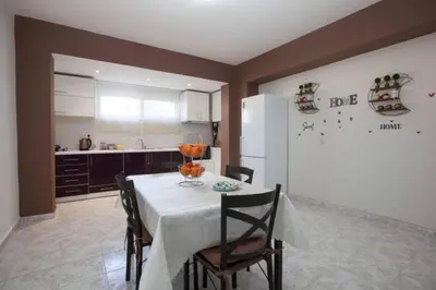 a kitchen with a table with chairs and a refrigerator at Natural Quiet Accommodation 2 in Kalithies