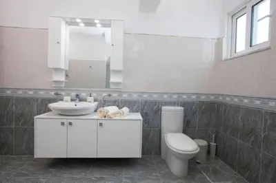 a bathroom with a sink and a toilet and a mirror at Natural Quiet Accommodation 2 in Kalithies