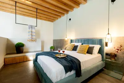 a bedroom with a large bed with a blue headboard at Lindos Serenity Suites in Líndos