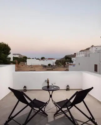 a table and chairs on a balcony with a view at Lindos Serenity Suites in Líndos