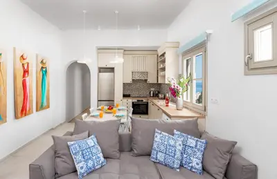 a living room with a couch and a kitchen at Lindos orchid villa in Líndos