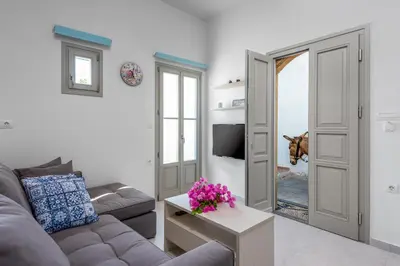 a living room with a couch and a dog looking in a mirror at Lindos orchid villa in Líndos