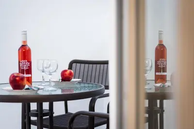 two tables with wine glasses and apples on them at Lindos orchid villa in Líndos