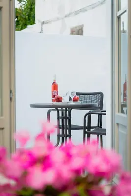 a table and chairs with pink flowers on a patio at Lindos orchid villa in Líndos